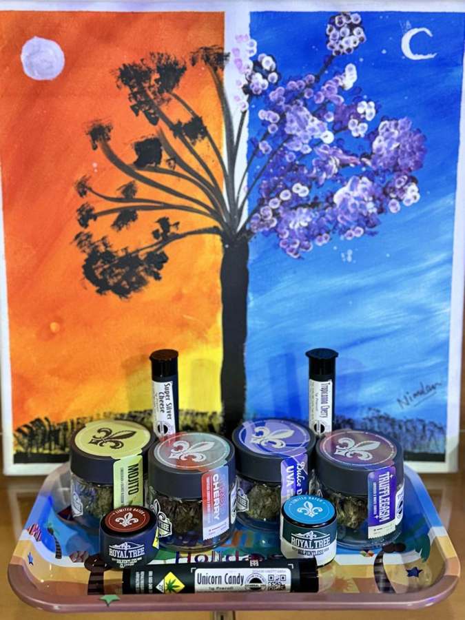 Washington cannabis products arranged on a painted tray in front of a tree painting